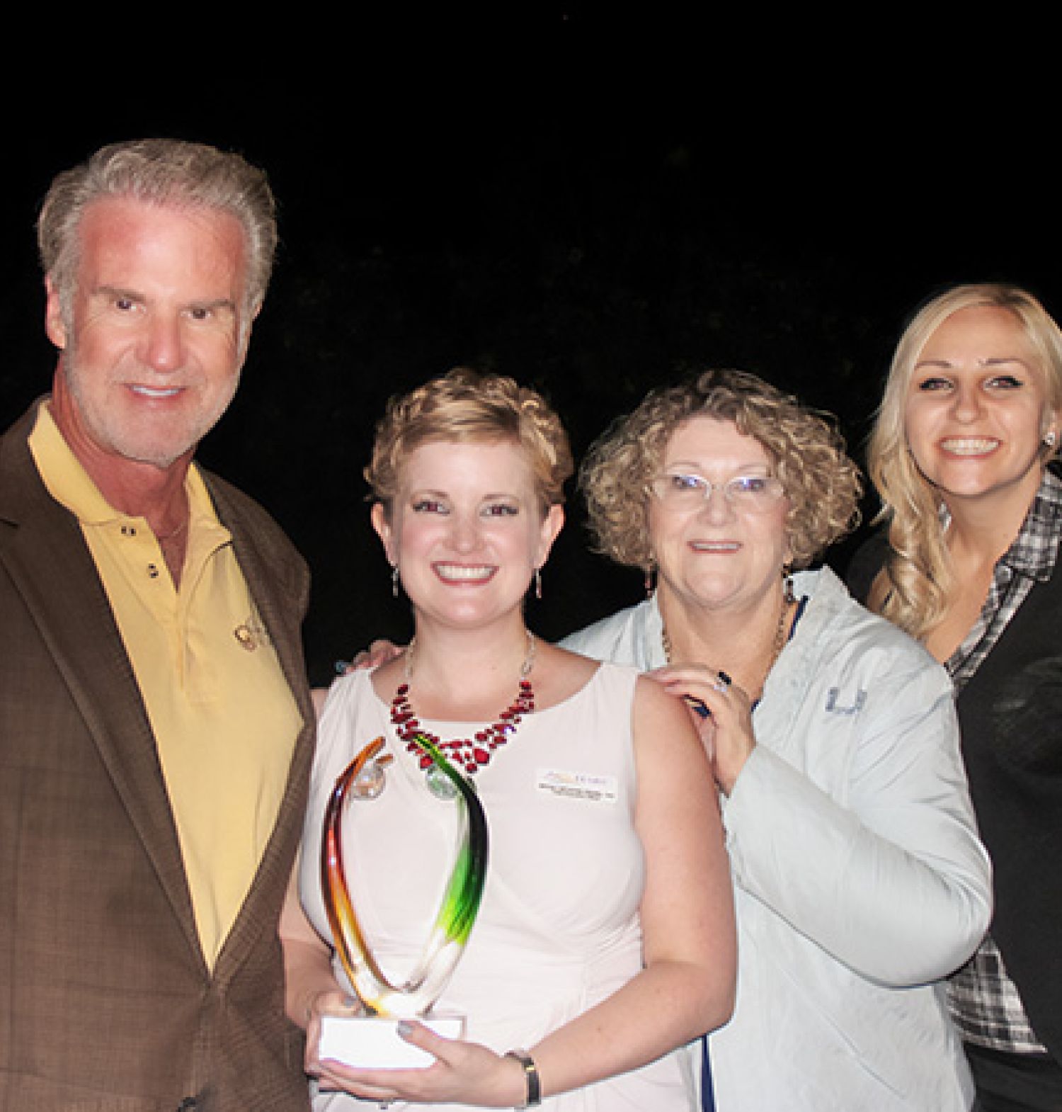 HARC CEO, Jenna LeComte-Hinely holding an award and surrounded by former HARC CEO, Eileen Parker, and Director of Research, Casey Leier